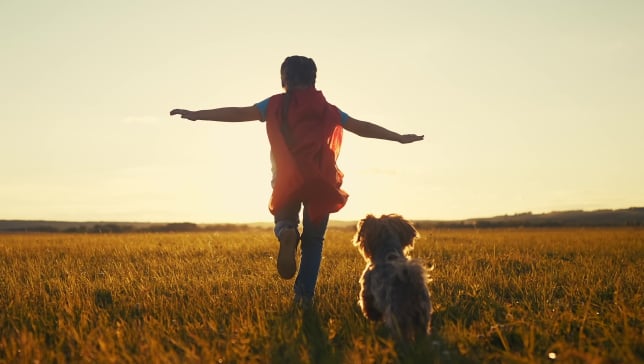 dijete bezbrižno trči uz psa